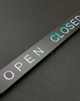 Rectangular 'Open' and 'Closed' sign on a dark surface