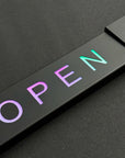 Neon sign with the word 'OPEN' on a black background