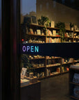 Bookstore interior with 'OPEN' sign visible through glass door