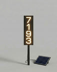 Solar-powered address sign with numbers on a gray background