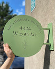 Green sign with text and address on a building exterior