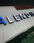 Blue acrylic front lit channel letters with stainless steel silver trim for office building