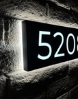 Halo lit address numbers creating a floating glowing effect on the wall