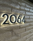 Illuminated address numbers 2064 installed on residential brick exterior