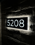 Illuminated house numbers glowing brightly at night for easy home identification