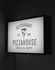 Illuminated wall mounted pizza restaurant sign featuring modern branding on brick w