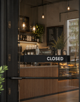 Black Open / Closed slider sign on a coffee shop glass door showing CLOSED