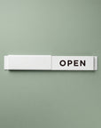 White and black Open / Closed slider signs stacked side by side