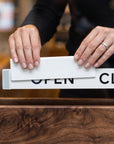 Close-up of hands sliding the panel to switch between OPEN and CLOSED