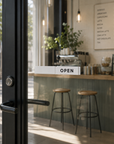 White Open / Closed slider sign on a sunlit café entrance with OPEN showing