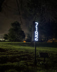 Solar powered staked address sign installed on front lawn for modern curb appeal