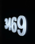 Side view of floating 3D address numbers showing hidden LED spacers and depth