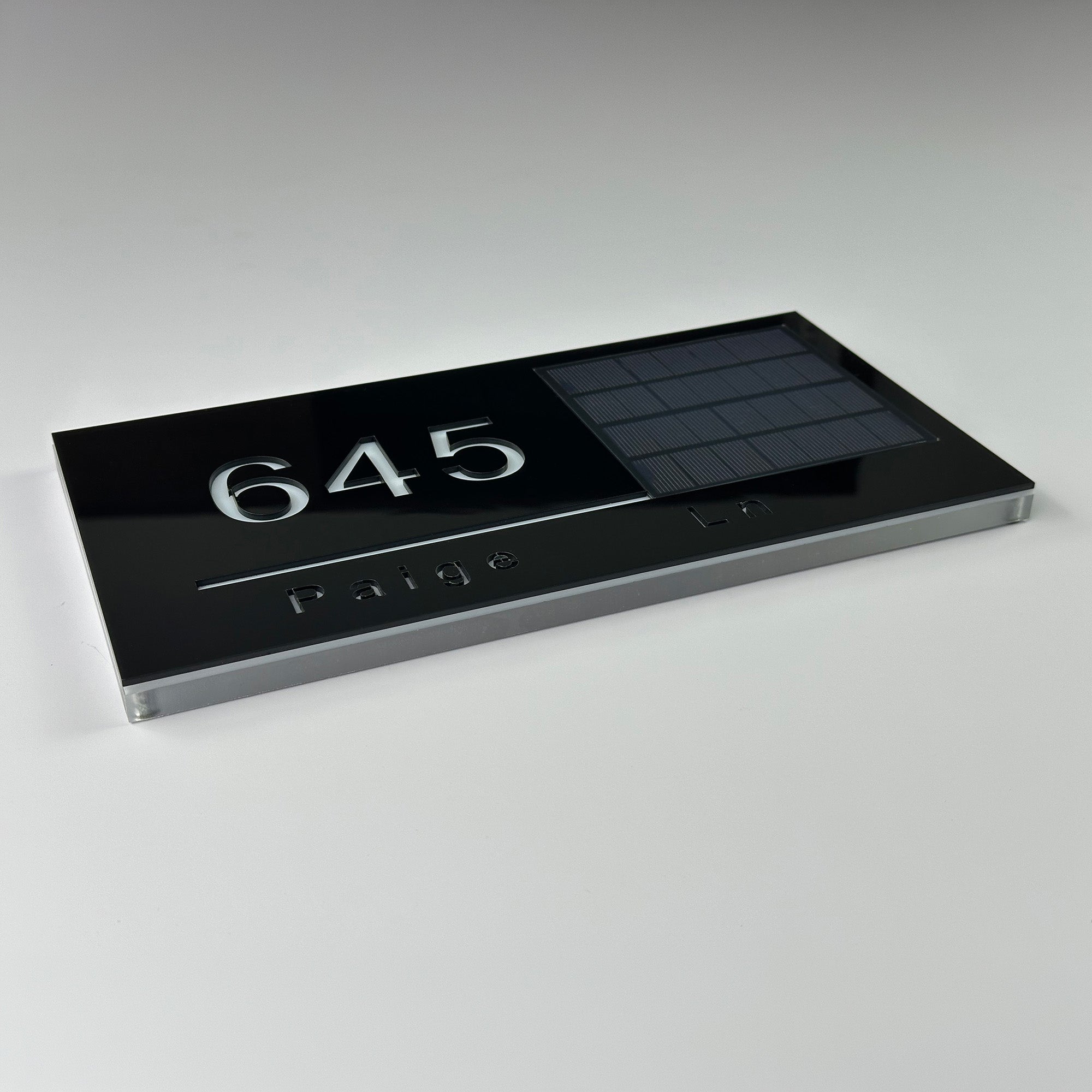 Outdoor solar address plaque with illuminated numbers and integrated solar panel