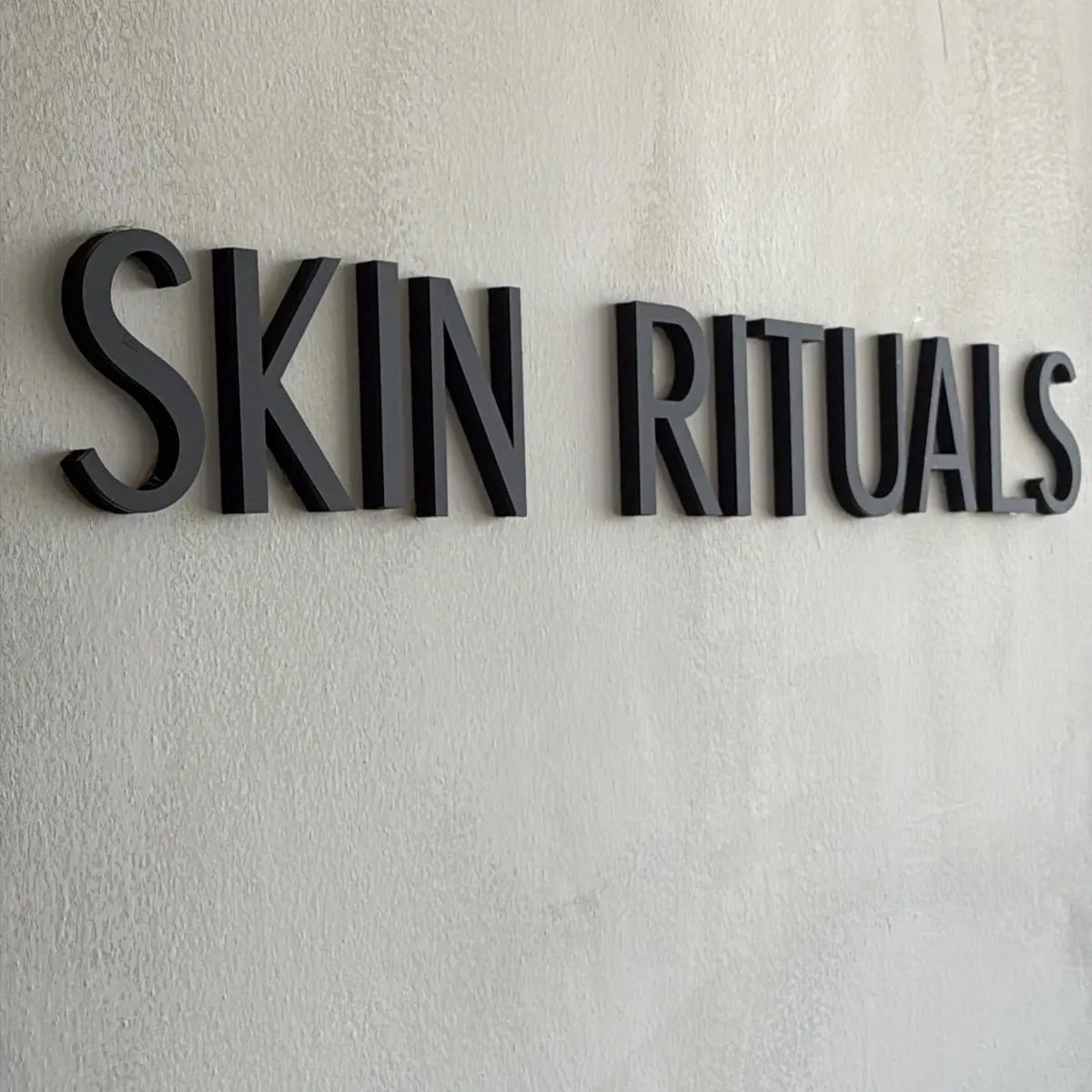 Custom black 3D dimensional business sign mounted on a modern interior wall