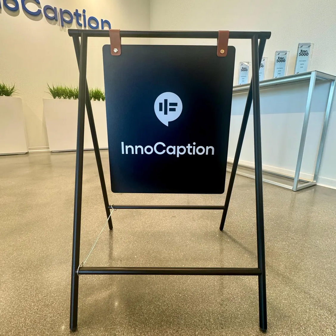 Portable matte black A-frame sandwich board sign featuring the logo and branding