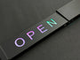 Neon sign with the word 'OPEN' on a black background