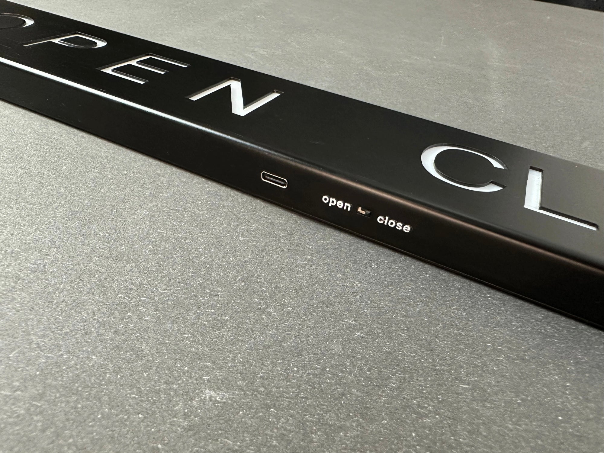 Black door handle with 'open' and 'close' labels on a metallic surface
