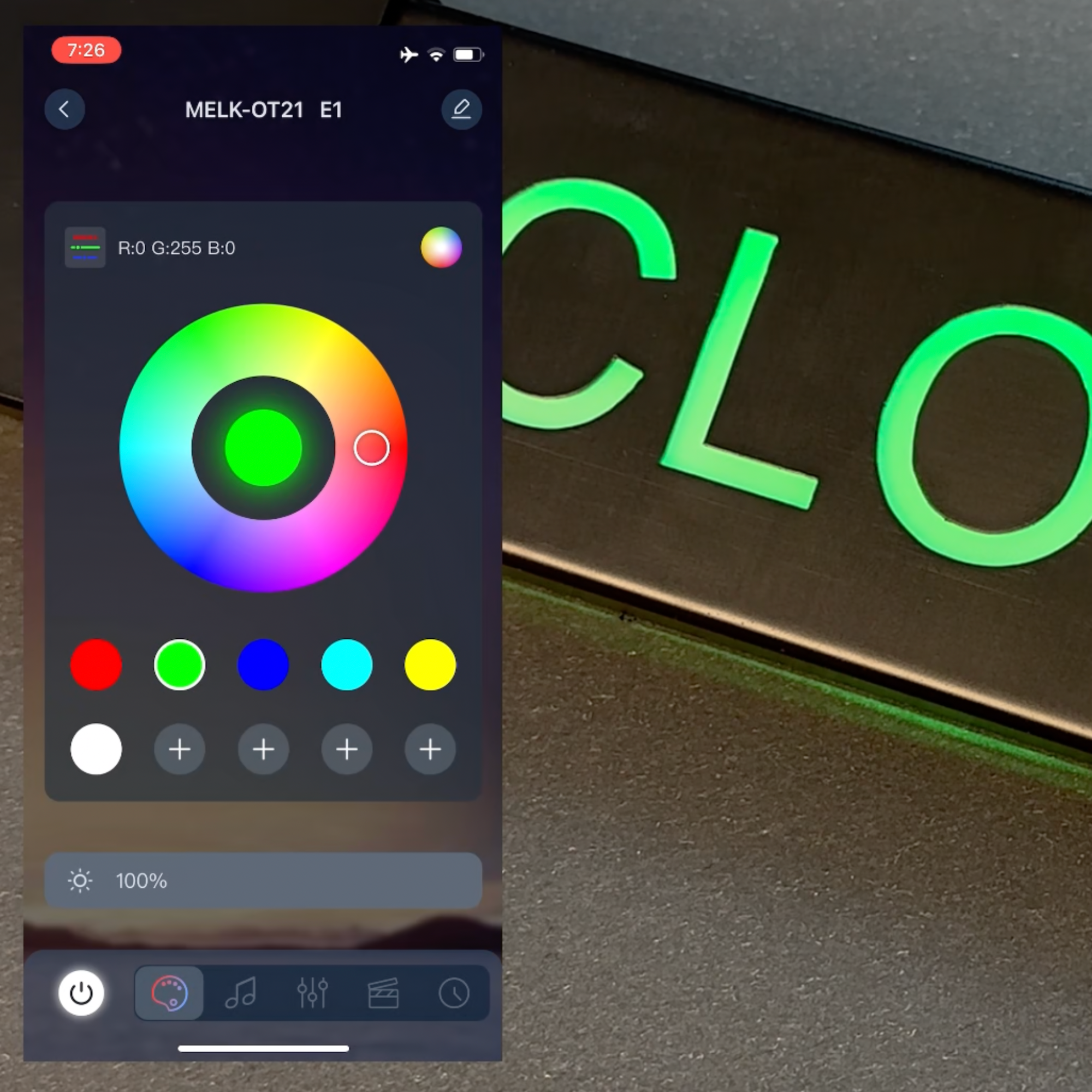 Color wheel app on a smartphone with a neon green sign in the background