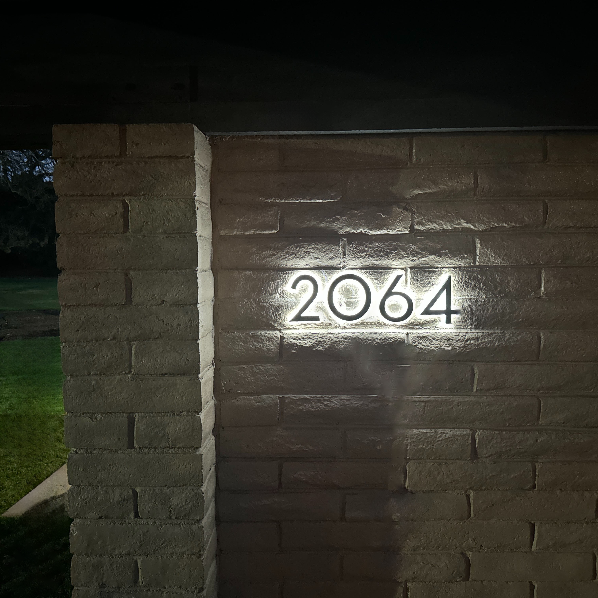Lighted house numbers mounted on wood siding with hidden wiring