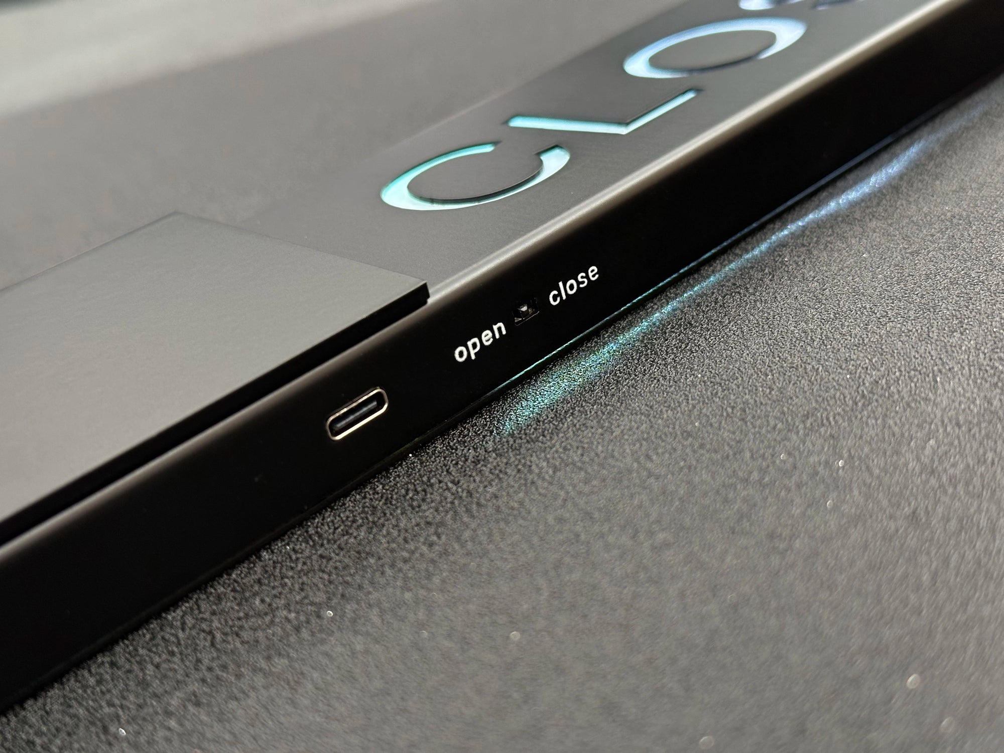 Close-up of a device with 'open' and 'close' labels on a dark surface