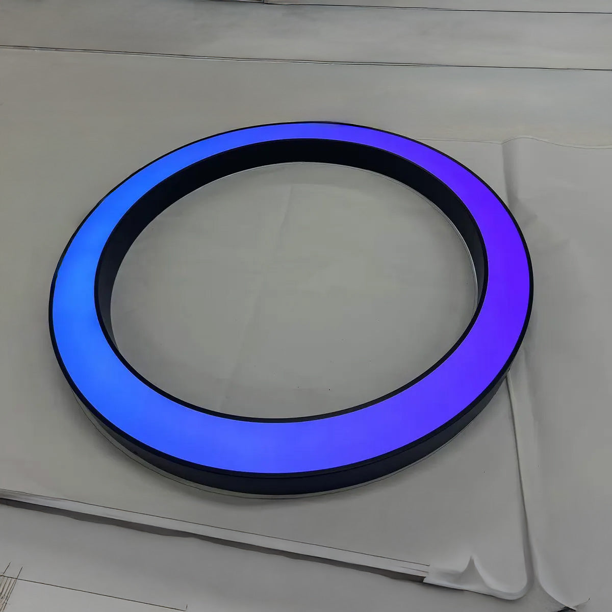 Round LED business logo sign with blue illumination and 3D depth for storefronts