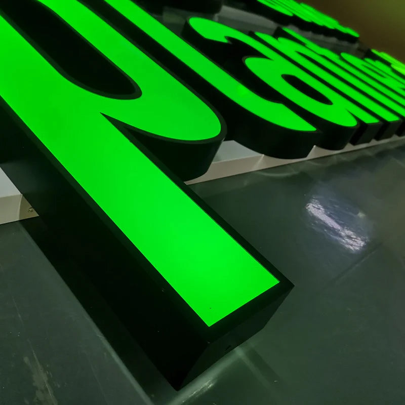 Side view of green acrylic 3D letter sign showing durable stainless steel construction