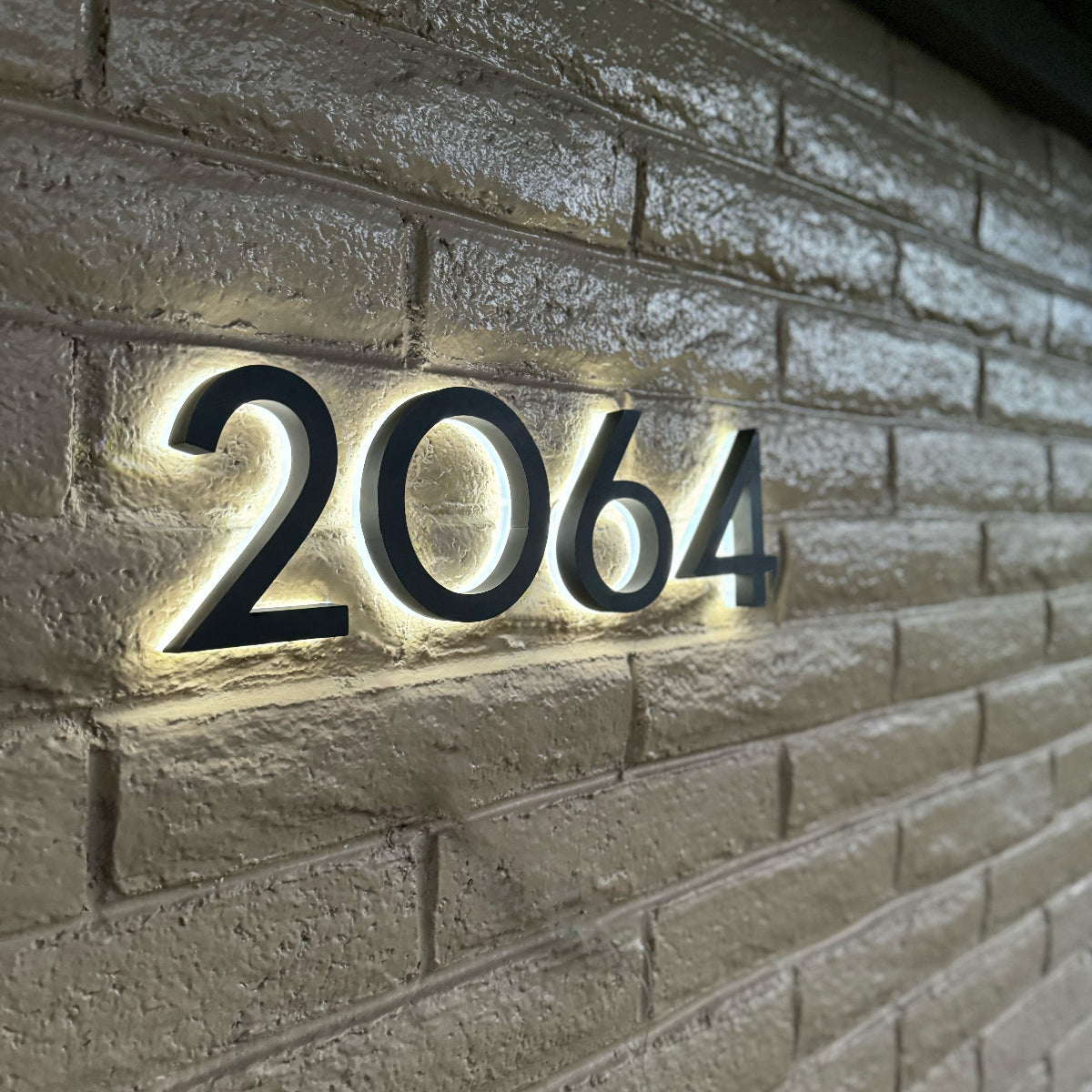 Illuminated address numbers 2064 installed on residential brick exterior