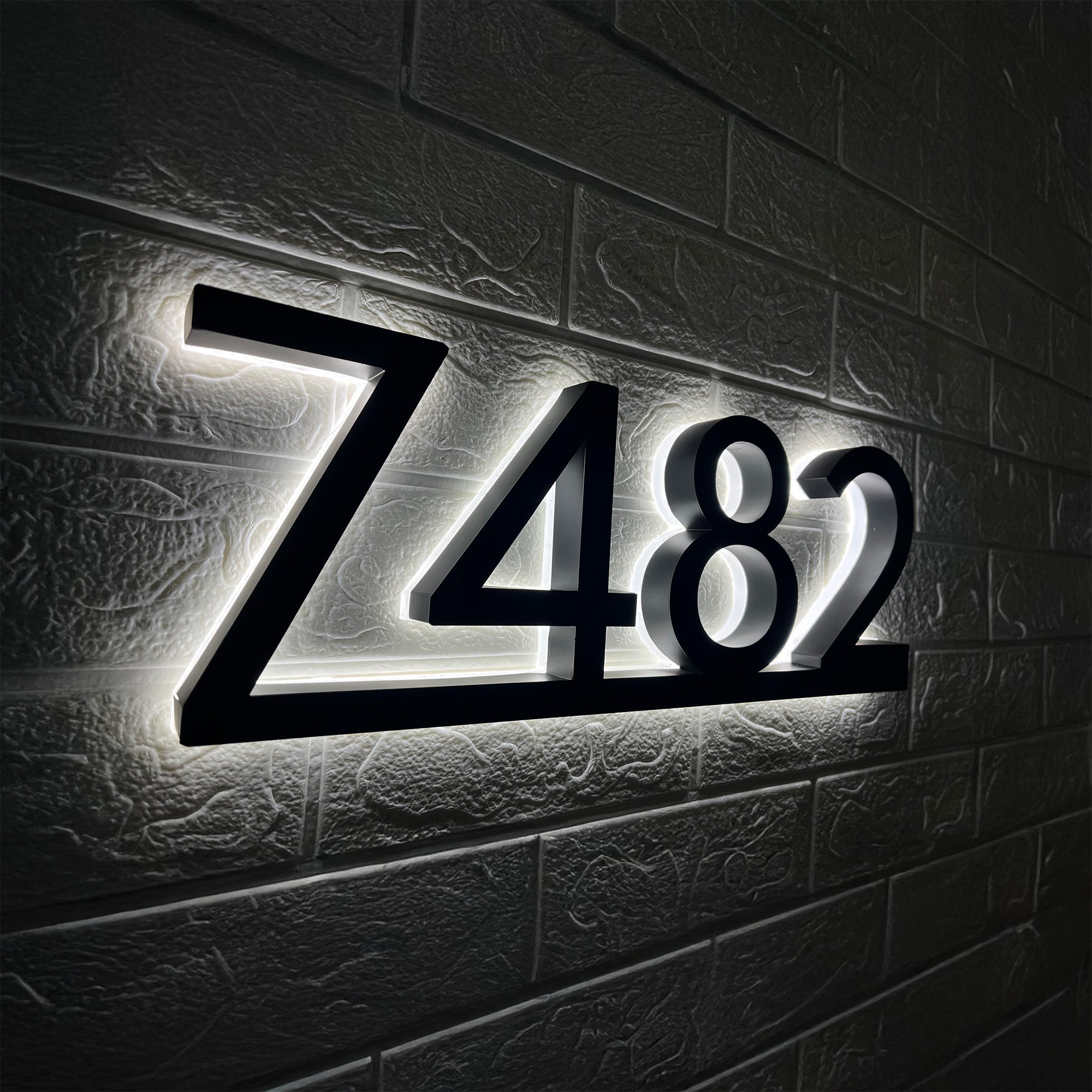 Illuminated floating house numbers with underline glowing at night