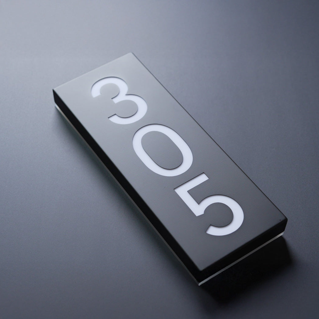 Rectangular metal sign with '305' on a dark background