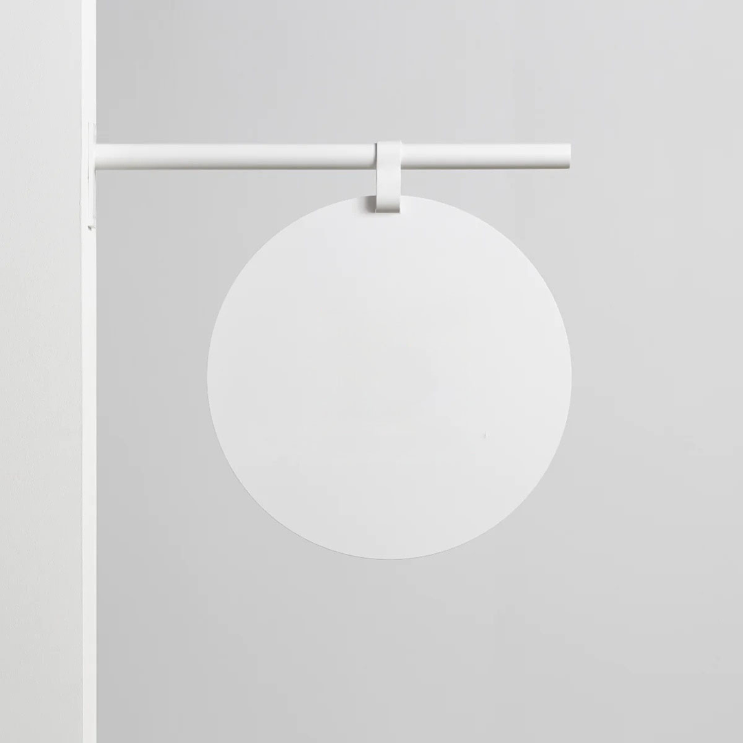 Minimalist white round blade sign for modern boutique entrance