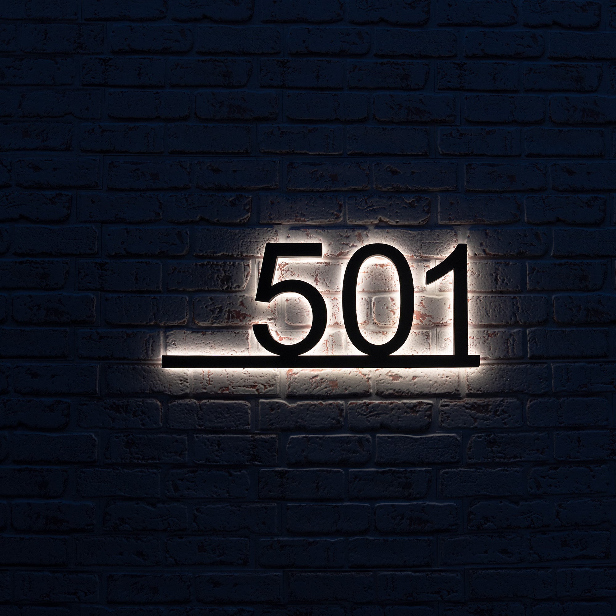 Modern address plaque with underline mounted on residential brick wall